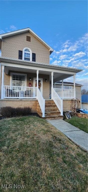 view of front facade with covered porch and a front lawn