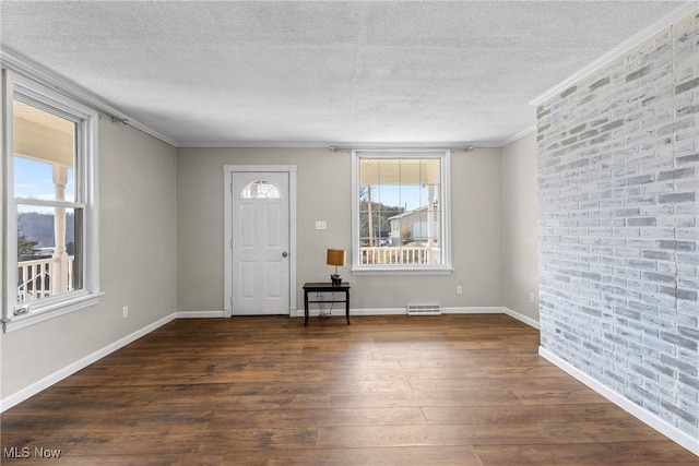 entrance foyer featuring a textured ceiling, dark wood-style flooring, and baseboards