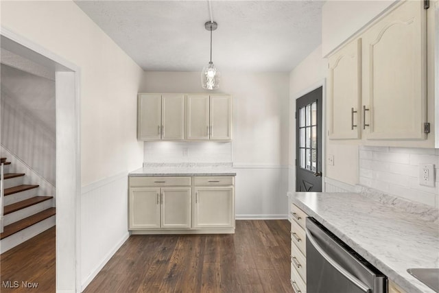 kitchen featuring pendant lighting, cream cabinetry, light countertops, dark wood-type flooring, and dishwasher