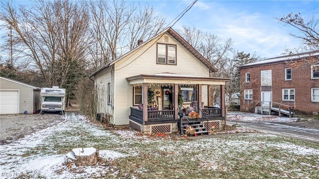 bungalow featuring an outbuilding, a porch, and a garage