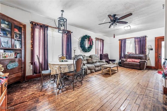 dining area featuring ceiling fan, wood-type flooring, and a textured ceiling