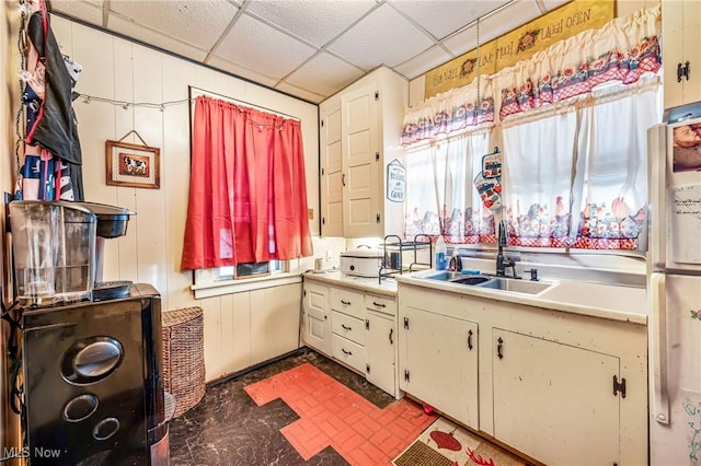 kitchen featuring a drop ceiling, white refrigerator, and sink