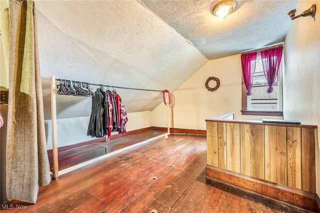 bonus room with hardwood / wood-style floors, lofted ceiling, and a textured ceiling