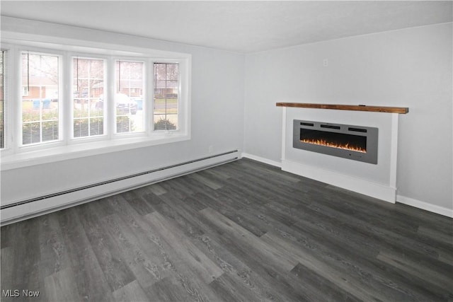 unfurnished living room with a baseboard radiator, a wealth of natural light, and dark hardwood / wood-style floors