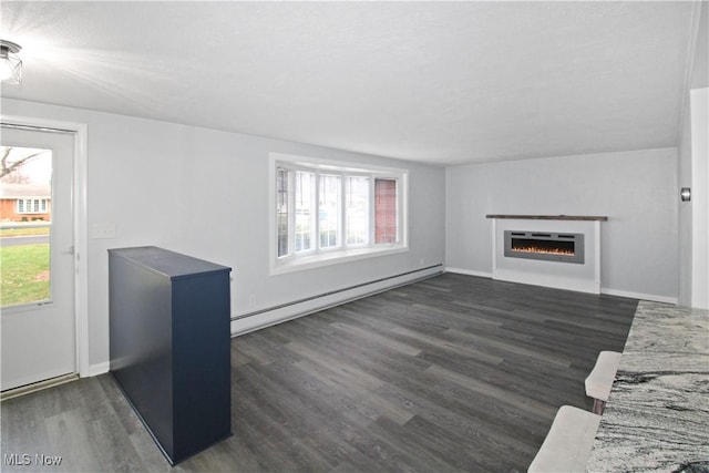 unfurnished living room featuring dark hardwood / wood-style flooring and a baseboard heating unit