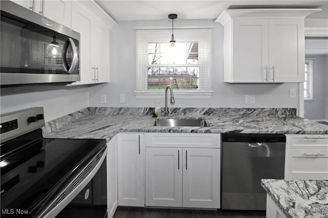 kitchen featuring white cabinets, appliances with stainless steel finishes, plenty of natural light, and sink