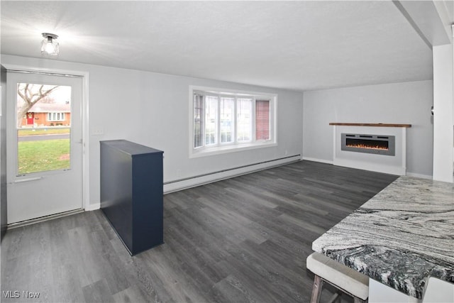 living room featuring dark wood-type flooring and a baseboard heating unit