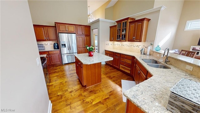 kitchen with decorative backsplash, stainless steel fridge, sink, and a kitchen island