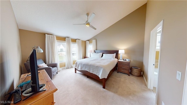 bedroom with ceiling fan, ensuite bathroom, high vaulted ceiling, and light colored carpet