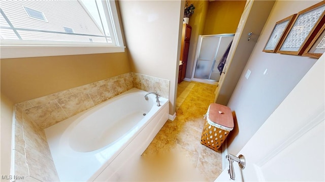 bathroom featuring shower with separate bathtub