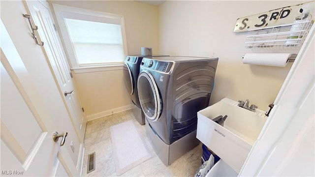 washroom featuring washer and clothes dryer and sink