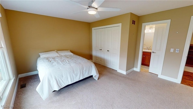 bedroom featuring ceiling fan, a closet, and light carpet