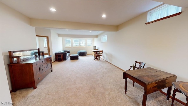 living area with beamed ceiling and light colored carpet