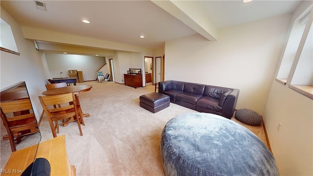 carpeted living room featuring beamed ceiling