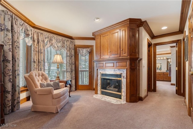 living area with ornamental molding, baseboards, a high end fireplace, and light carpet