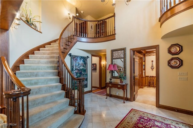 entryway featuring stairway, a high ceiling, and baseboards