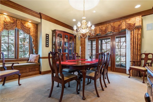 dining room with baseboards, french doors, light carpet, crown molding, and a chandelier