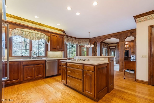 kitchen with a sink, ornamental molding, light countertops, dishwasher, and light wood-type flooring