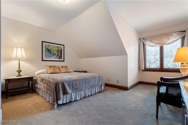 bedroom featuring light colored carpet, baseboards, and lofted ceiling