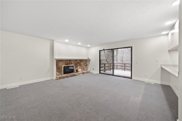 unfurnished living room featuring carpet and a stone fireplace