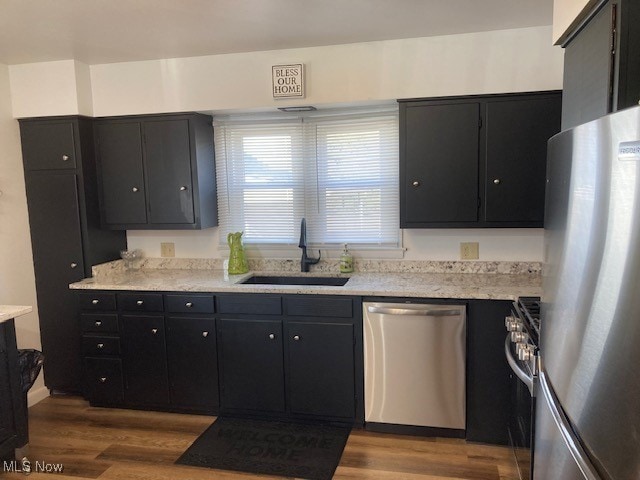 kitchen with sink, stainless steel appliances, and dark wood-type flooring