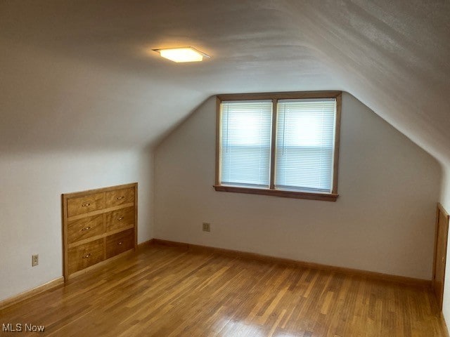 additional living space featuring hardwood / wood-style flooring and lofted ceiling