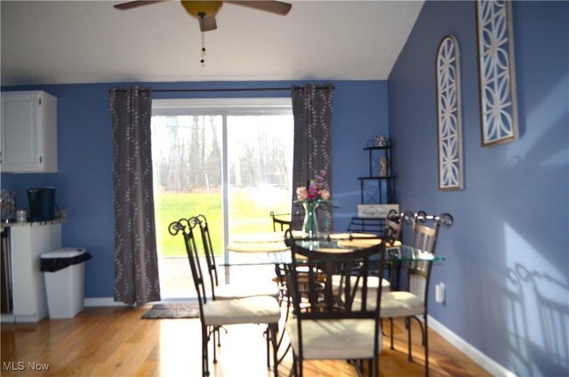 dining room with light hardwood / wood-style flooring, ceiling fan, and lofted ceiling