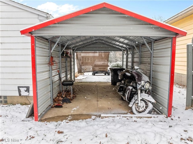 snow covered parking area featuring a carport