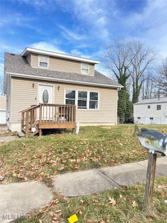 view of front of house with a wooden deck and a front lawn