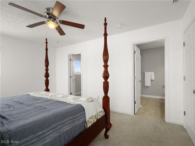 bedroom featuring light colored carpet, ceiling fan, and ensuite bathroom