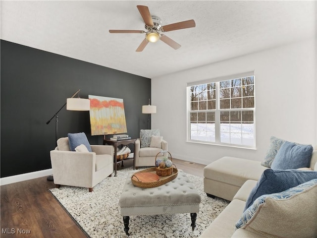 living room featuring ceiling fan and dark hardwood / wood-style flooring