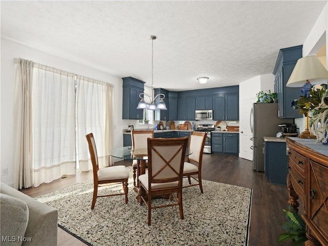 dining area with a textured ceiling, a notable chandelier, and dark wood-type flooring