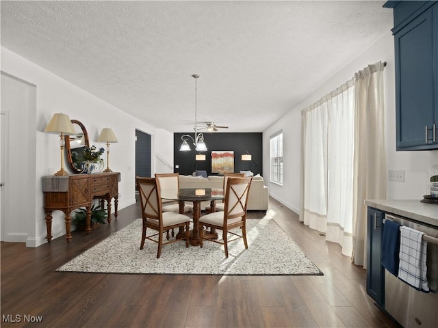 dining area with dark hardwood / wood-style floors, a textured ceiling, and an inviting chandelier