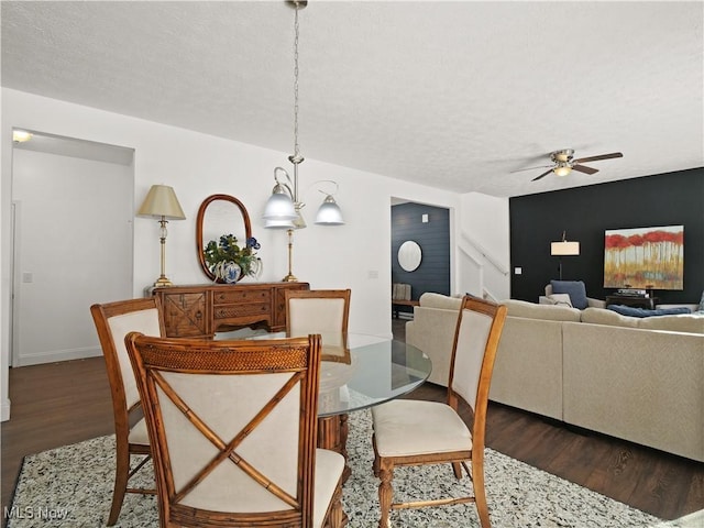 dining space featuring a textured ceiling, dark hardwood / wood-style floors, and ceiling fan with notable chandelier