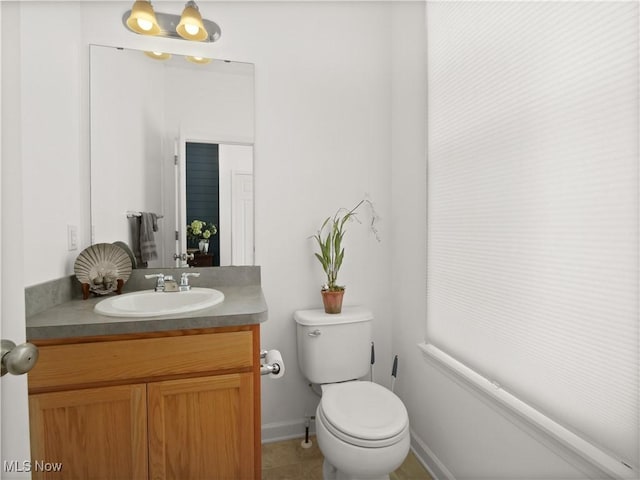 bathroom featuring tile patterned flooring, vanity, and toilet