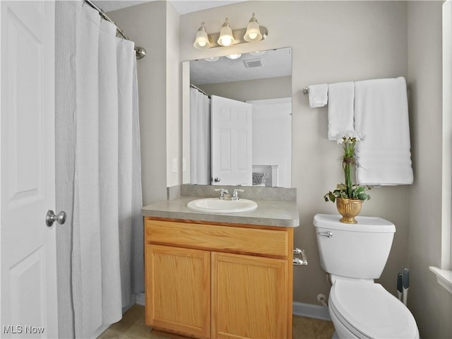 bathroom featuring tile patterned flooring, vanity, and toilet