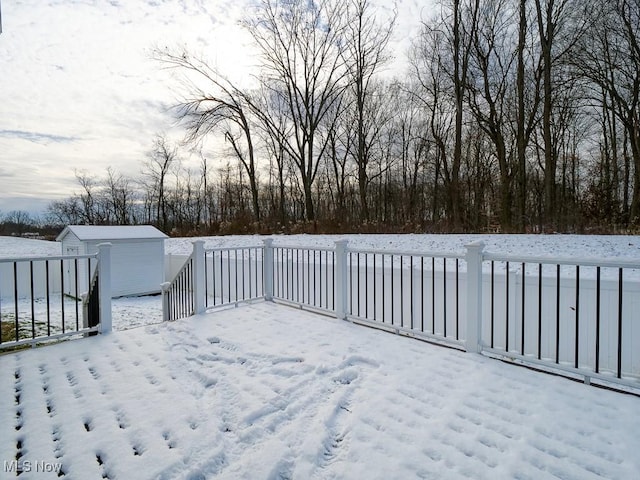 snow covered deck featuring a storage unit