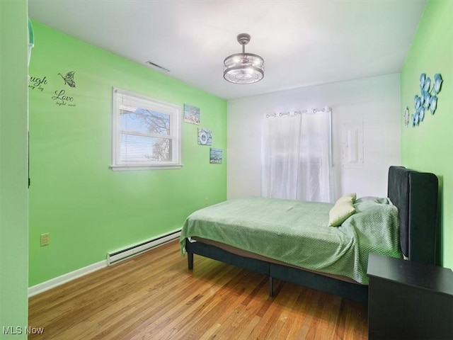 bedroom featuring hardwood / wood-style floors and a baseboard radiator