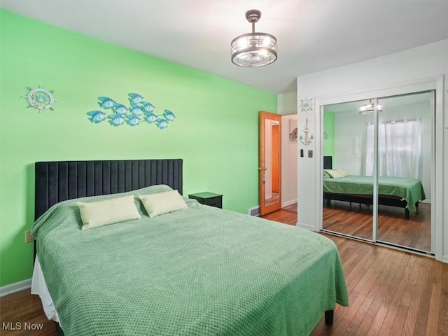 7630 Darling Ave, Conneaut, OH 44030 - bedroom with an inviting chandelier, wood-type flooring, baseboards, visible vents, and a closet