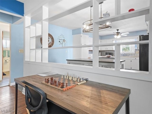 dining space featuring hardwood / wood-style floors and ceiling fan with notable chandelier