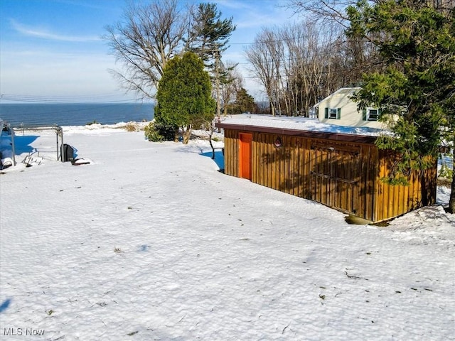 yard covered in snow with a water view