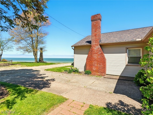 7630 Darling Ave, Conneaut, OH 44030 - view of home's exterior with a water view, roof with shingles, and a chimney