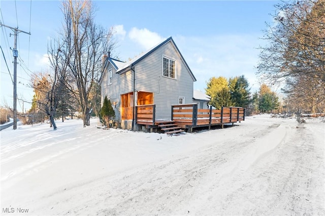 view of snow covered exterior featuring a wooden deck