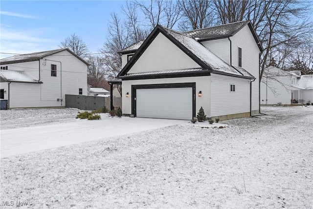 view of snow covered exterior featuring a garage