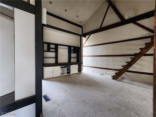 interior space with carpet and high vaulted ceiling