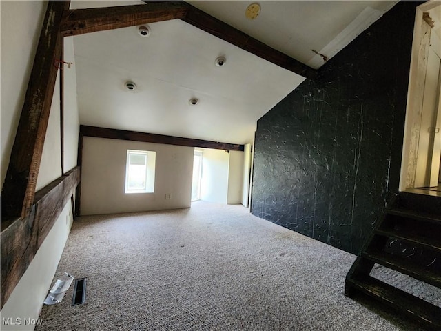 spare room with carpet and beam ceiling