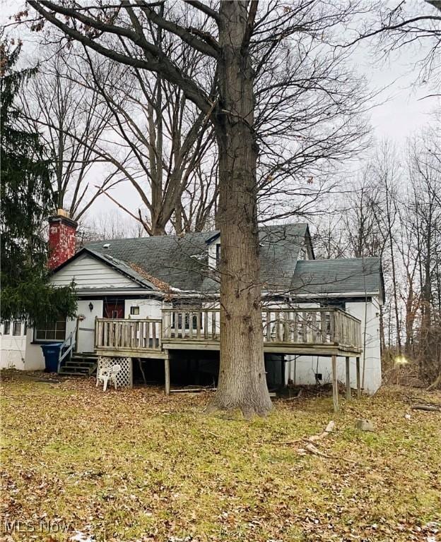 rear view of house with a sunroom and a deck