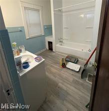 bathroom featuring shower / washtub combination, vanity, and hardwood / wood-style flooring