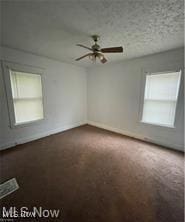 carpeted spare room with ceiling fan and a textured ceiling