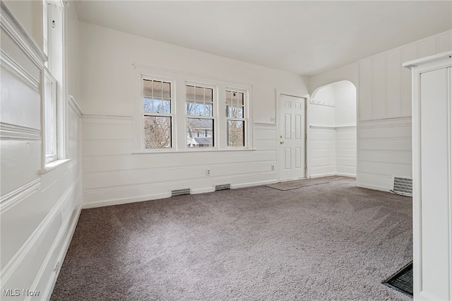 empty room with a healthy amount of sunlight and carpet floors